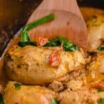 easy crock pot tuscan chicken recipe in a black slow cooker