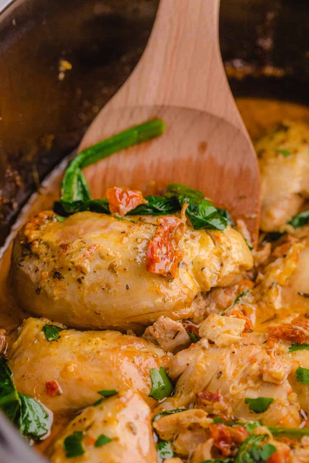 easy crock pot tuscan chicken recipe in a black slow cooker