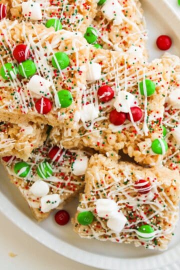 Red white and green Christmas Rice Krispies cut into squares and served on a white plate.