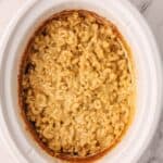 Crockpot Creamy Mac and Cheese that's been cooked in a white slow cooker