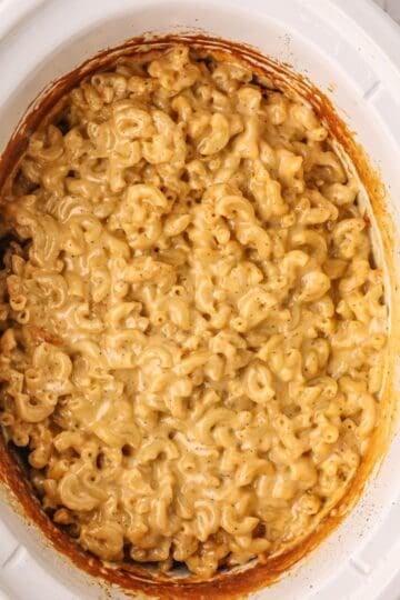 Crockpot Creamy Mac and Cheese that's been cooked in a white slow cooker