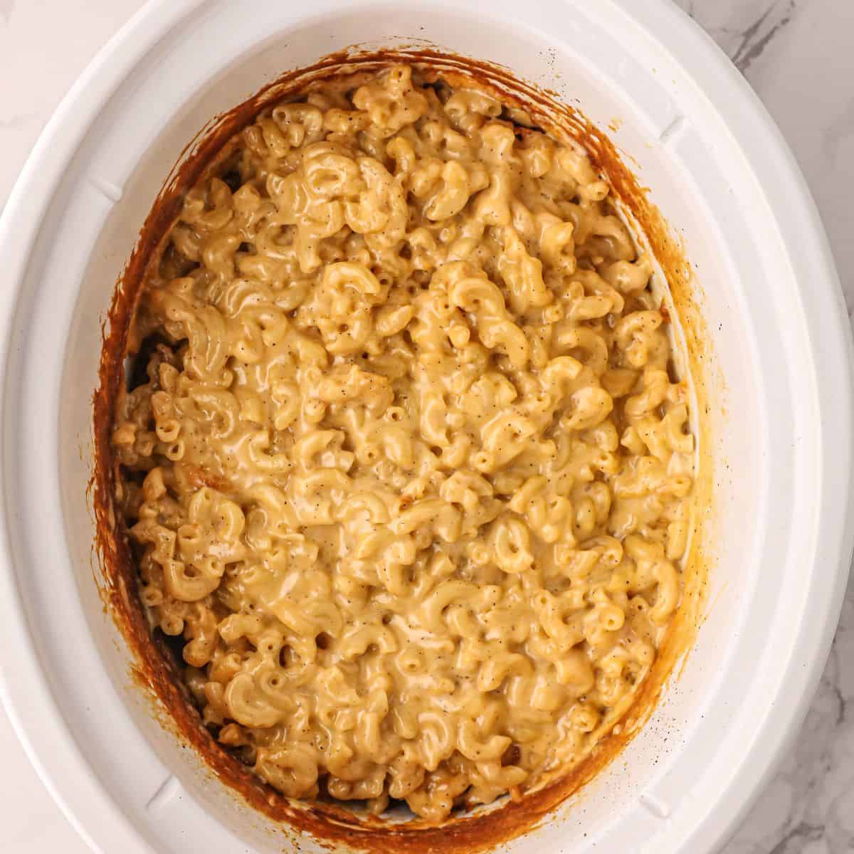 Crockpot Creamy Mac and Cheese that's been cooked in a white slow cooker