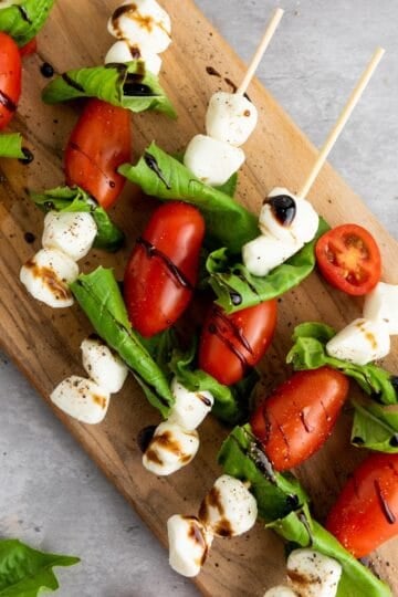 Easy Caprese Skewers laid out on a wooden board