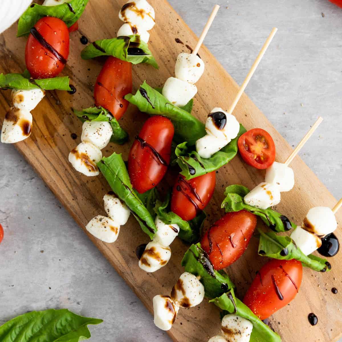 Easy Caprese Skewers laid out on a wooden board