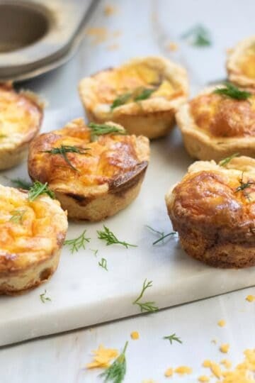 Mini Salmon Quiches being served on a marble counter