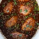 crock pot honey garlic chicken thighs in a white slow cooker