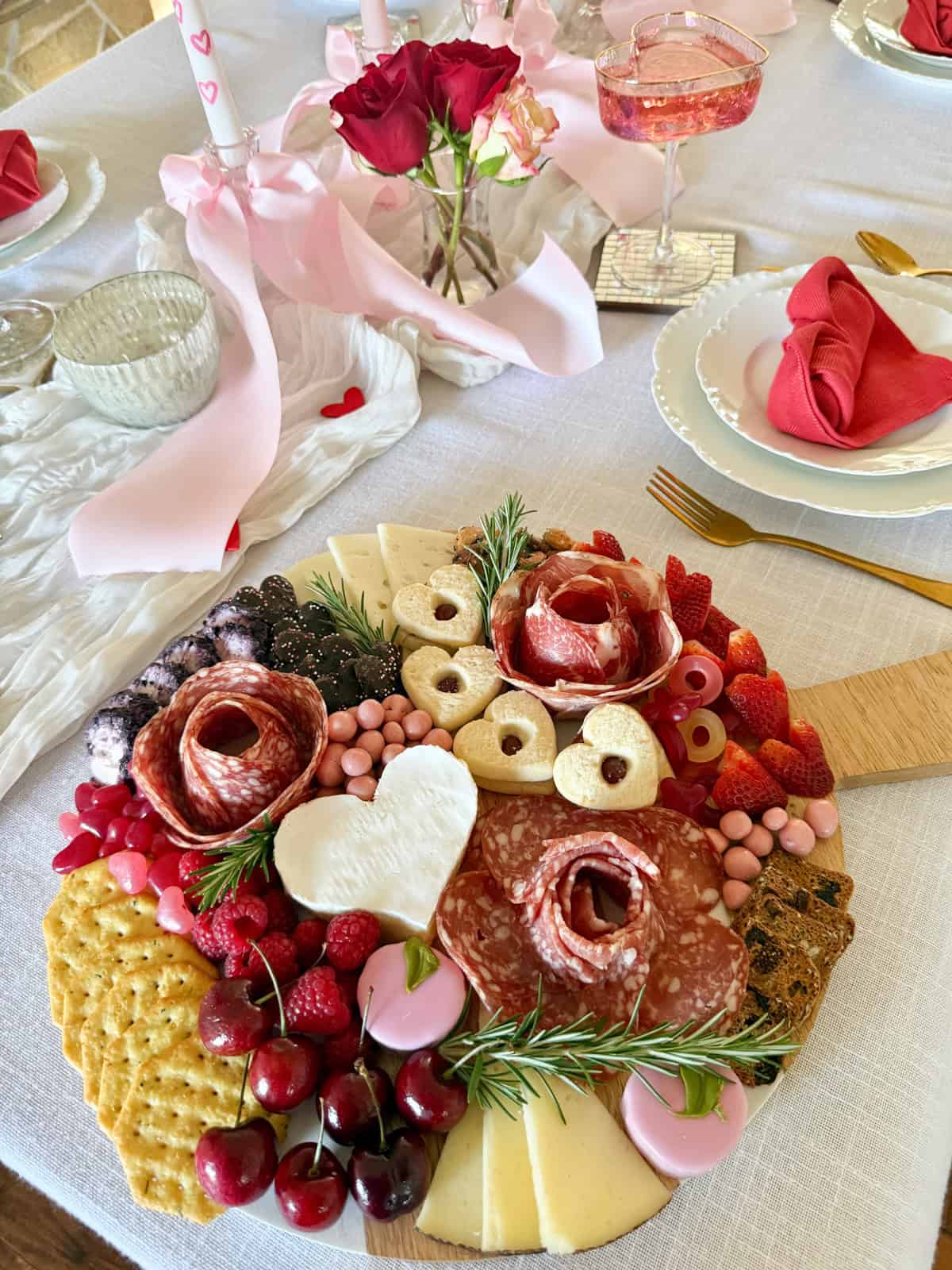 valentines charcuterie board thats red pink and white on a party table