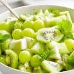easy green fruit salad in a white bowl on a white counter