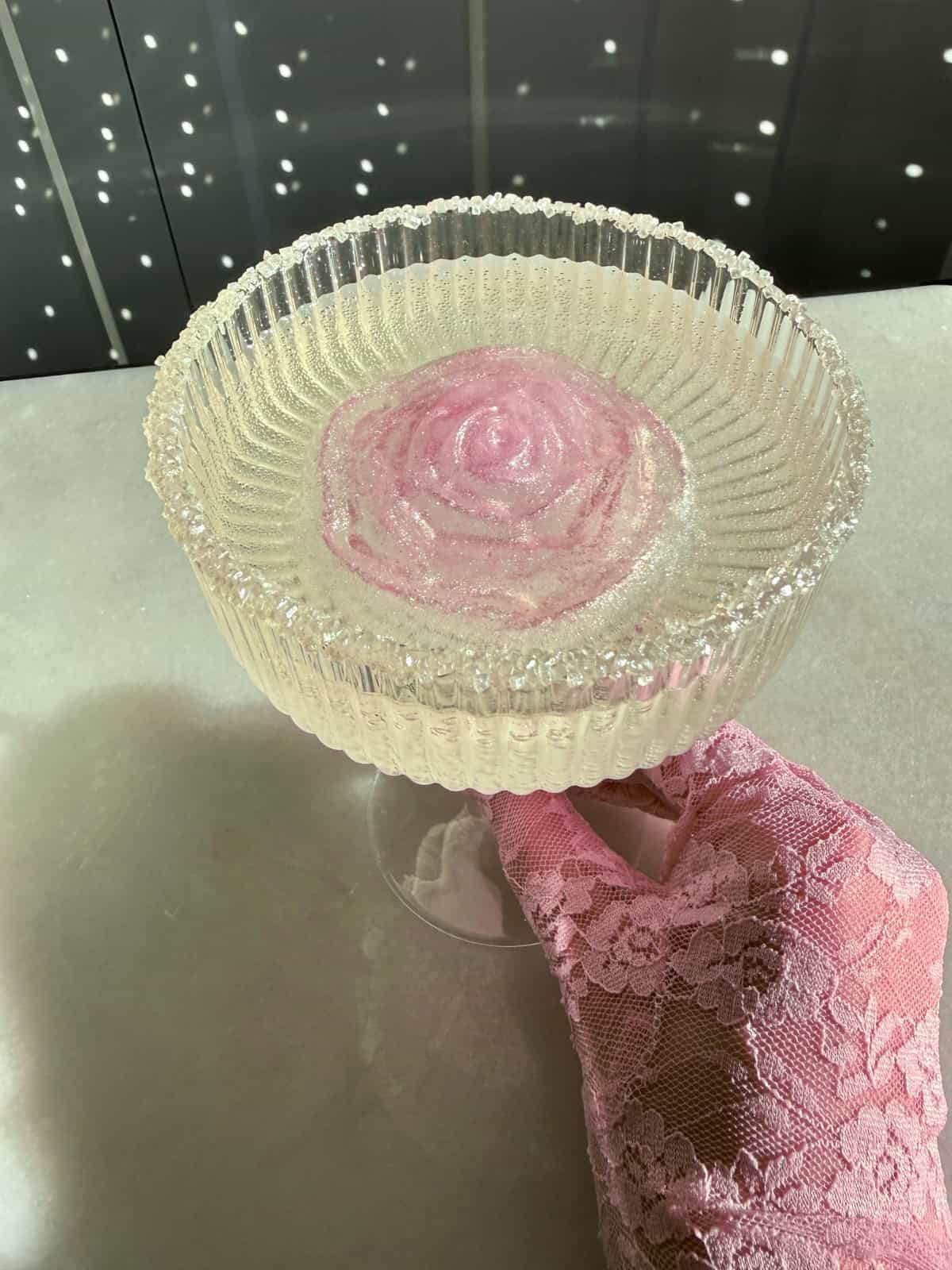 bridgerton cocktail with a rose ice cube and prosecco