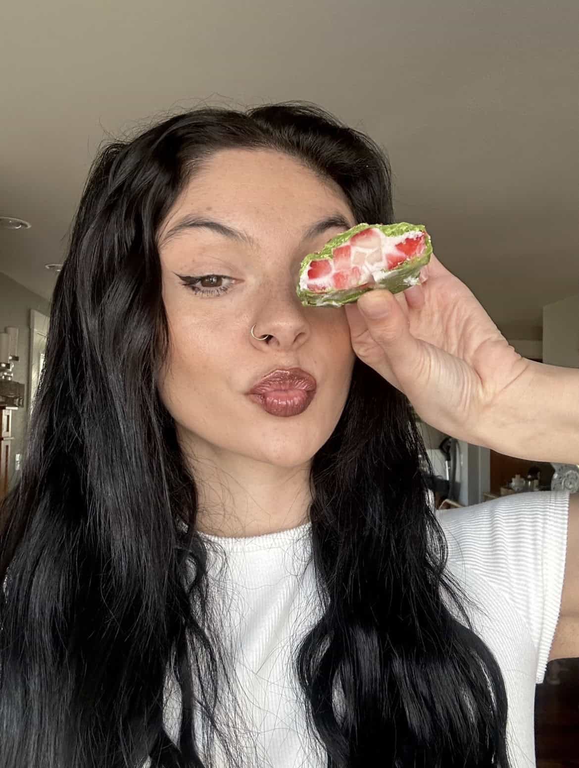 female with long black hair holding a no bake strawberry dessert with matcha and greek yogurt