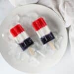red white and blue yogurt popsicles sitting on ice to keep cold.
