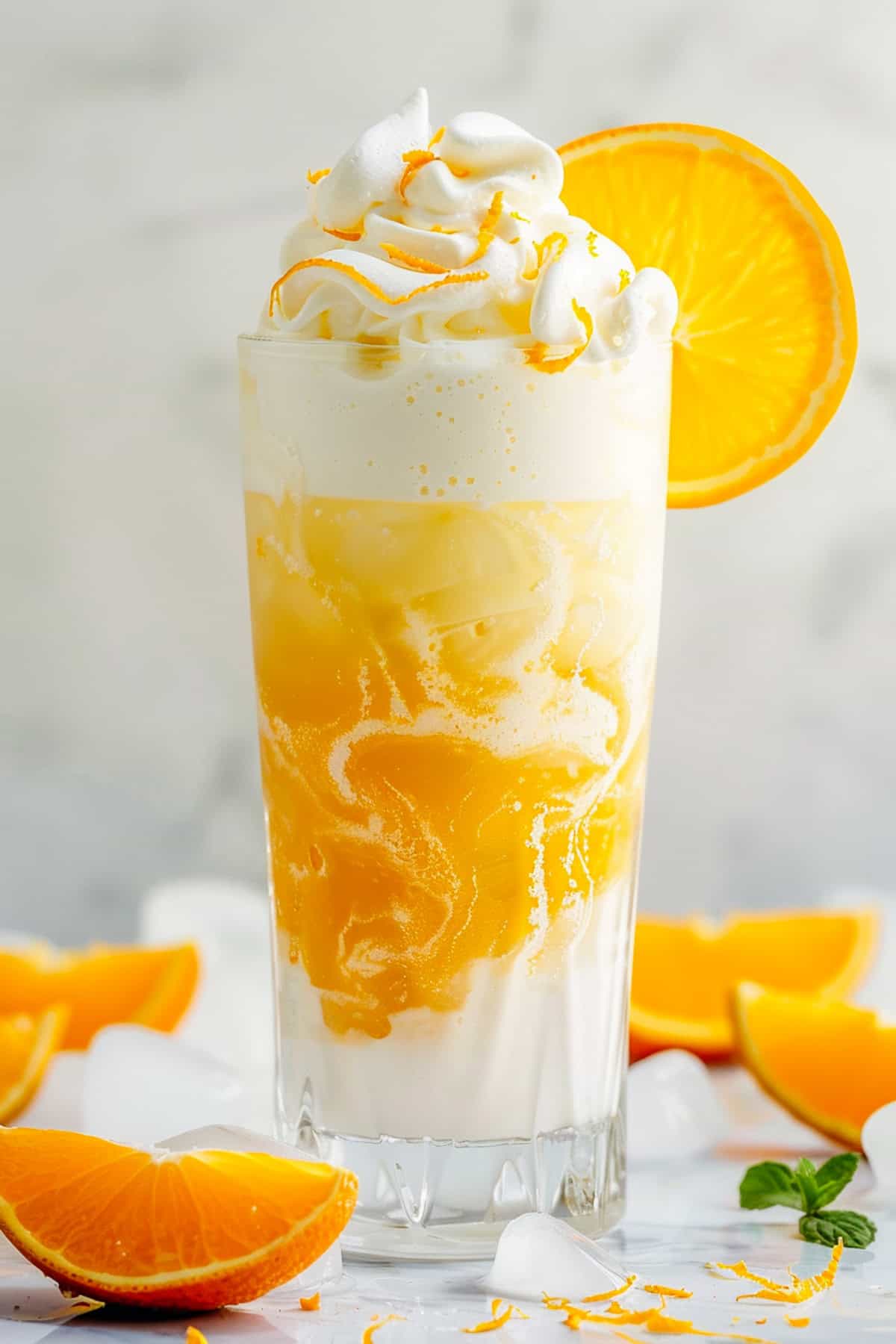 orange creamsicle dirty soda with sprite garnished with mint and orange slices
