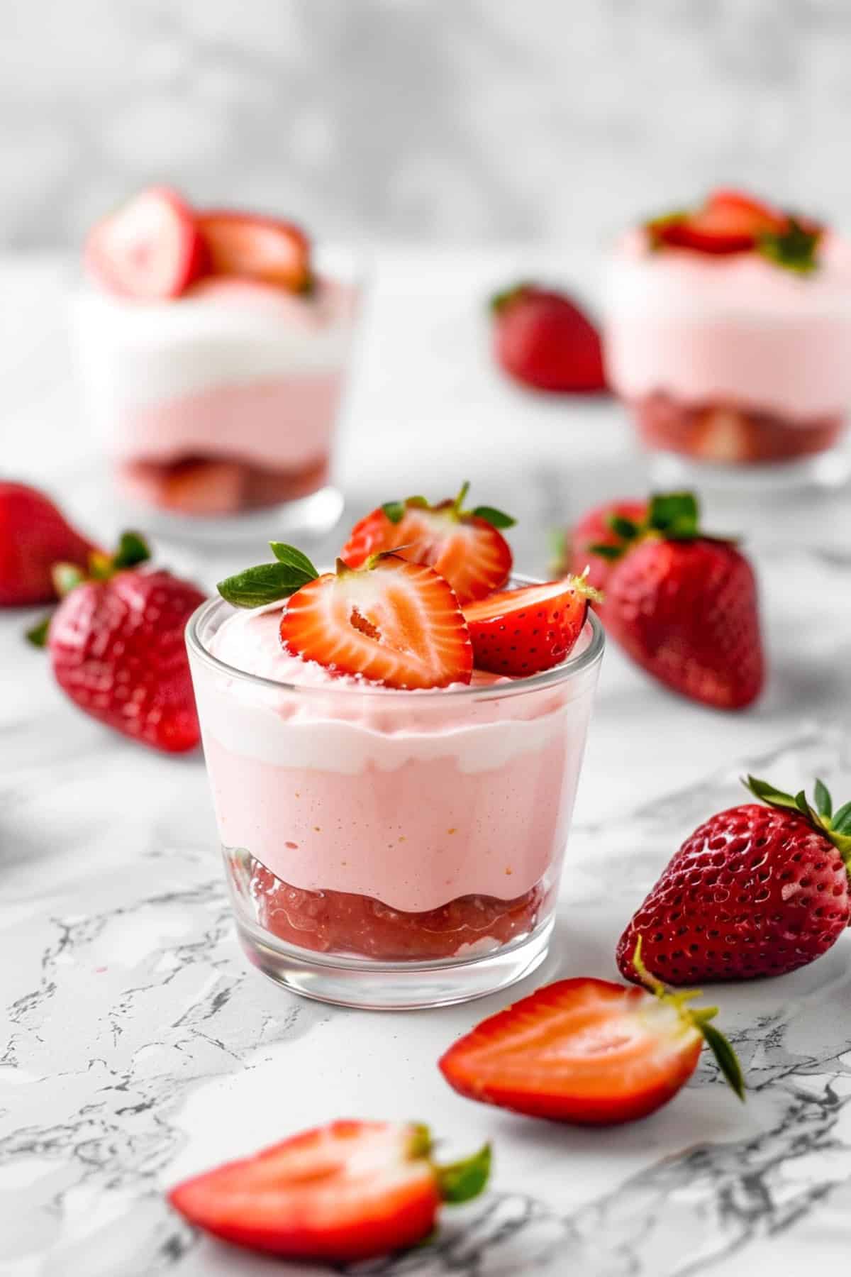 strawberry mousse cups in clear dishes on a white background