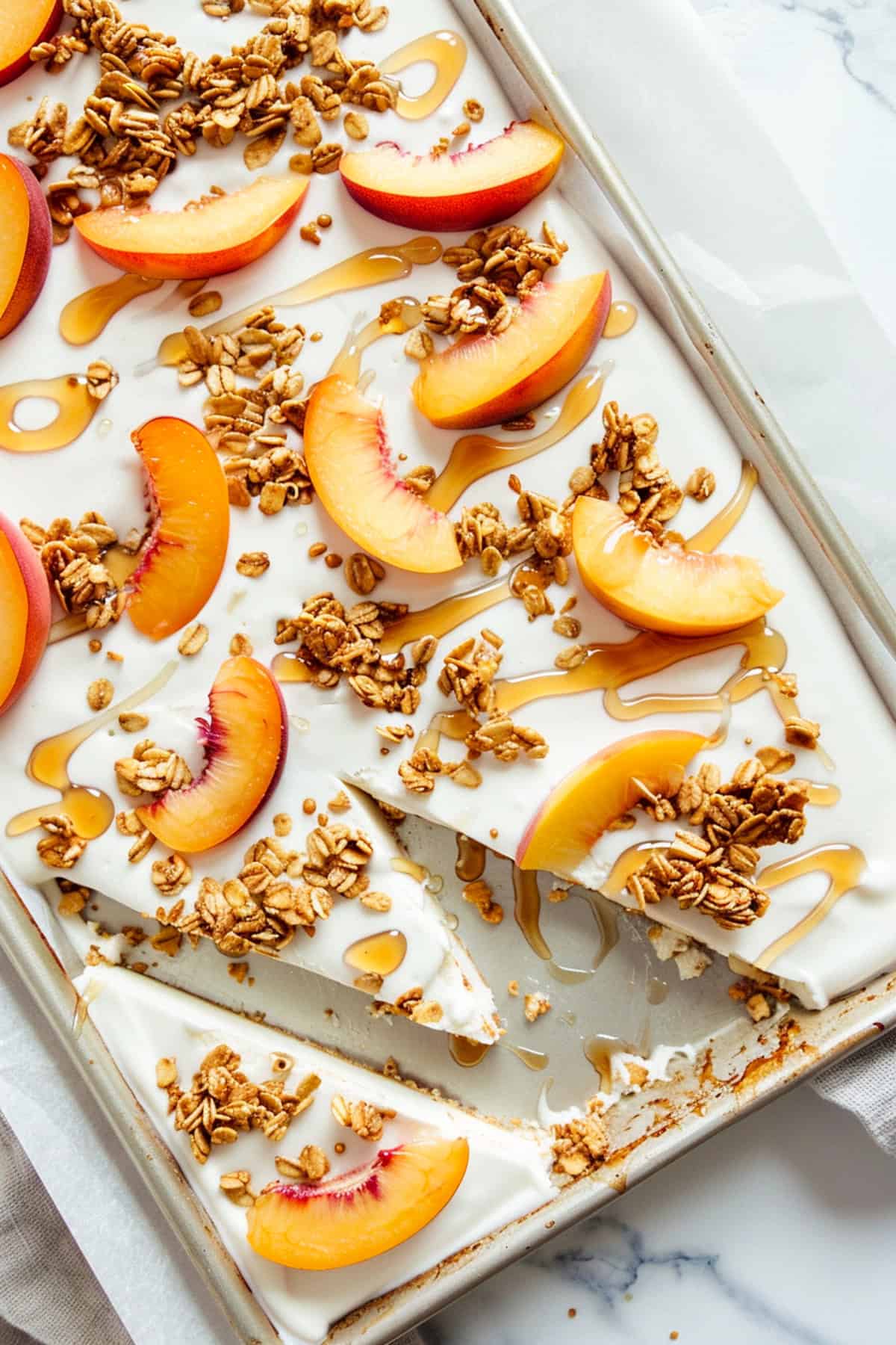 honey peach frozen yogurt bark cut into pieces on a cookie sheet