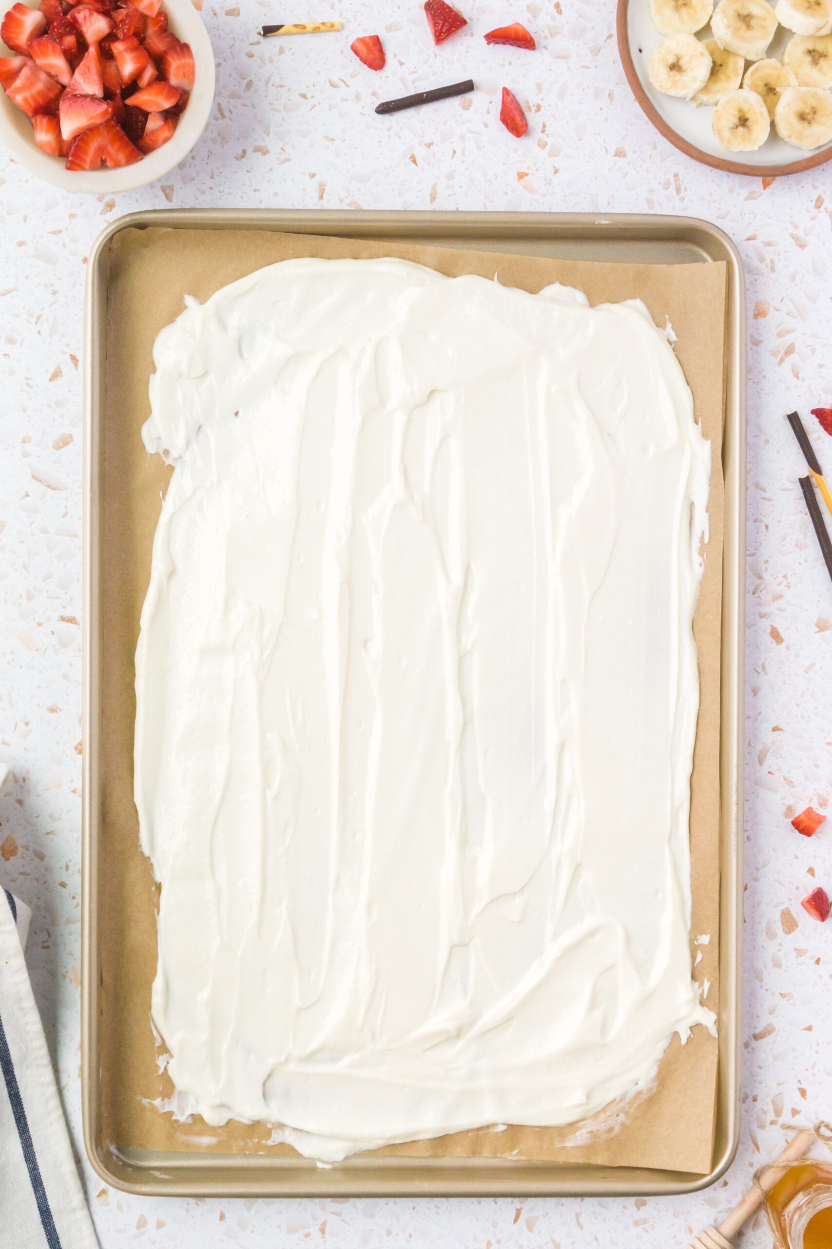 greek frozen yogurt getting spread on a cookie sheet