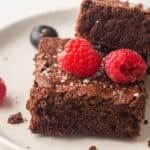Sheet pan brownies topped with raspberries.