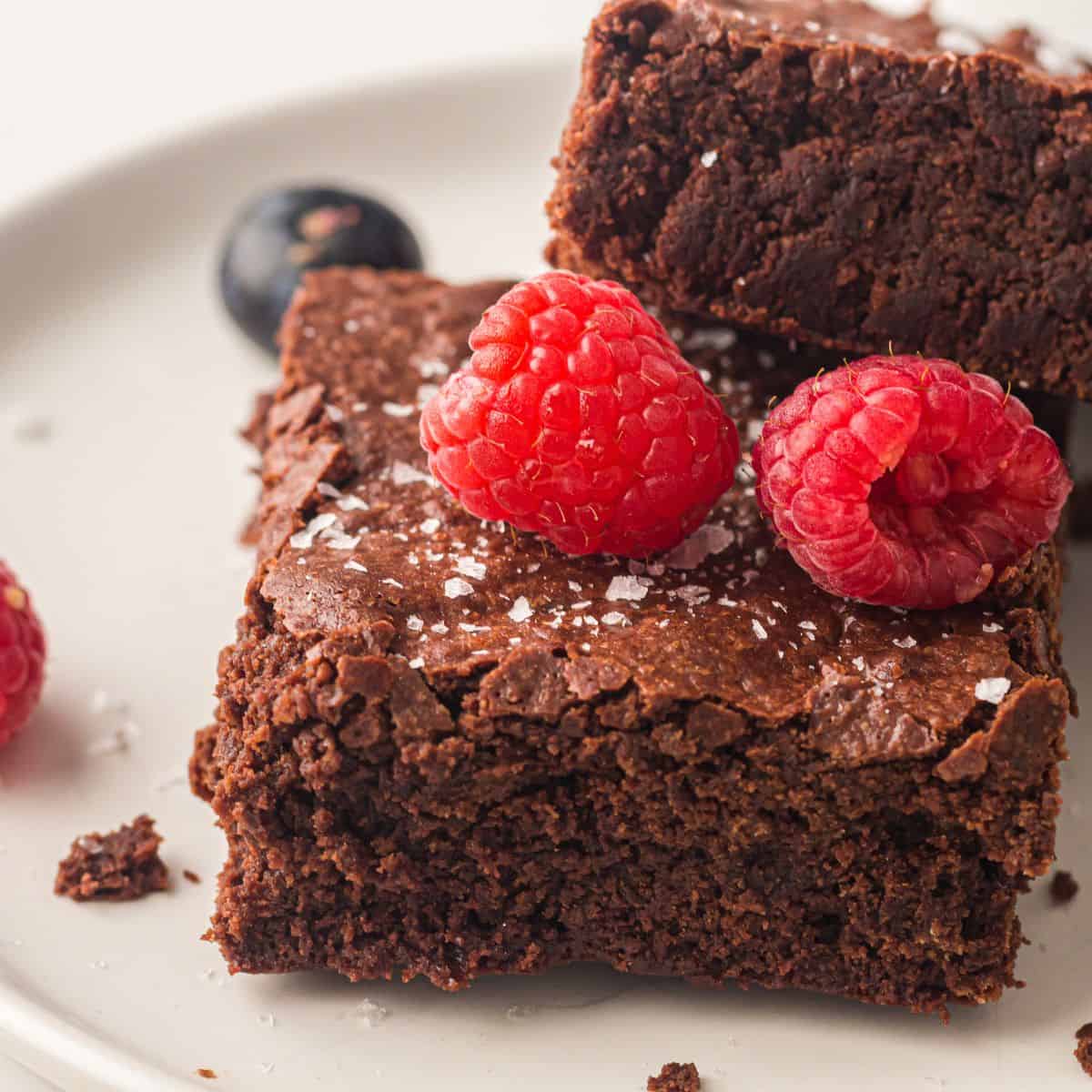 Sheet pan brownies topped with raspberries.