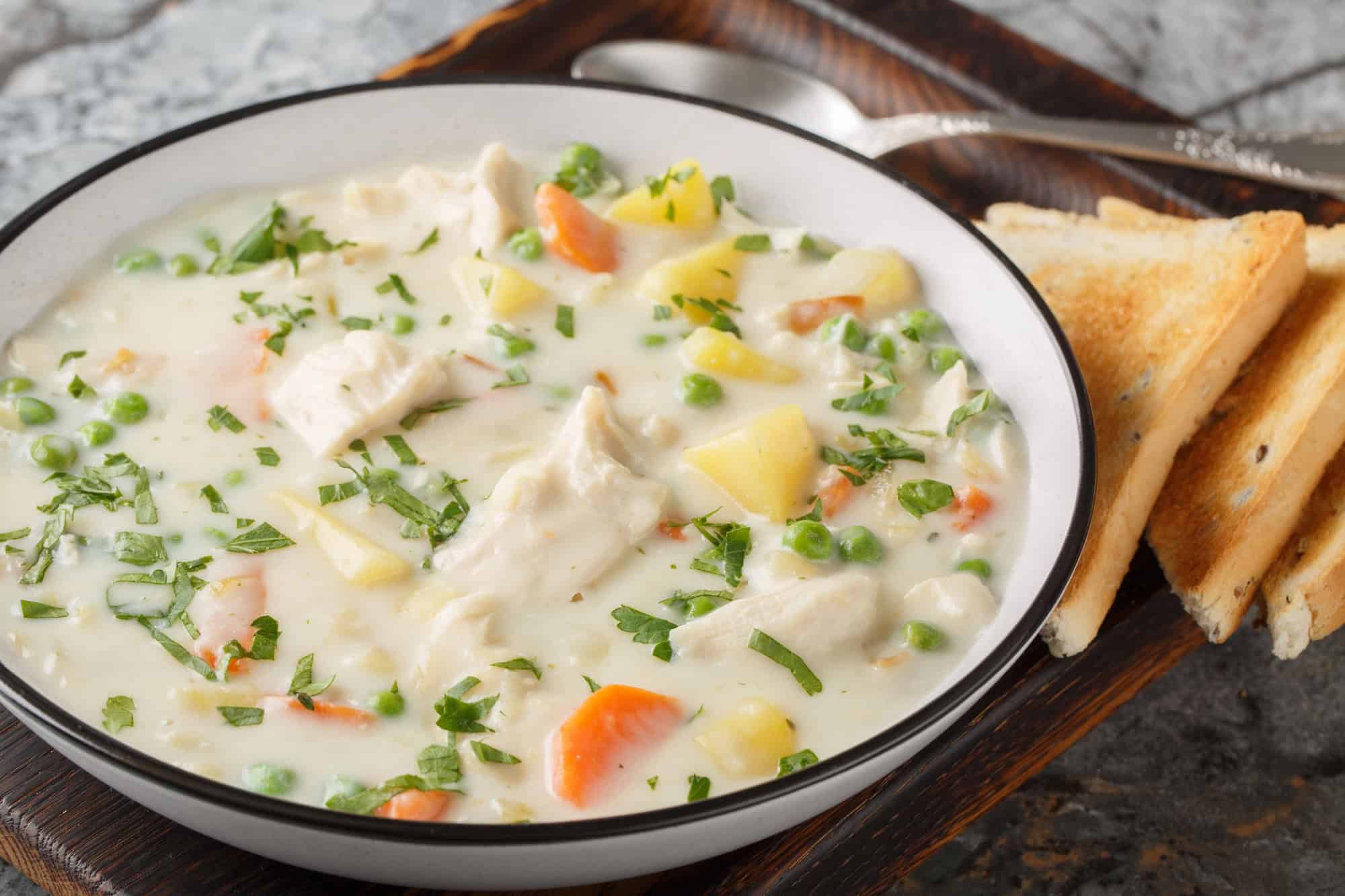 chicken pot pie soup made in a slow cooker served with toast