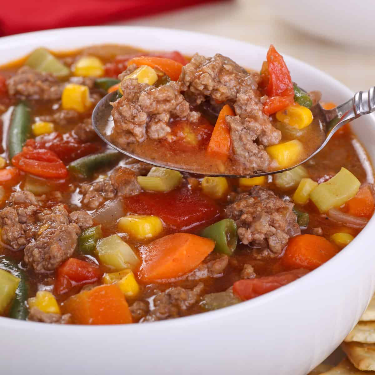 crock pot vegetable beef soup for fall with a bite on a spoon in a white bowl