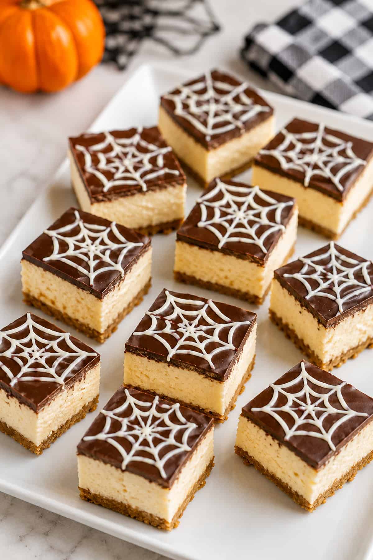 spiderweb cheesecake bites on a white plate