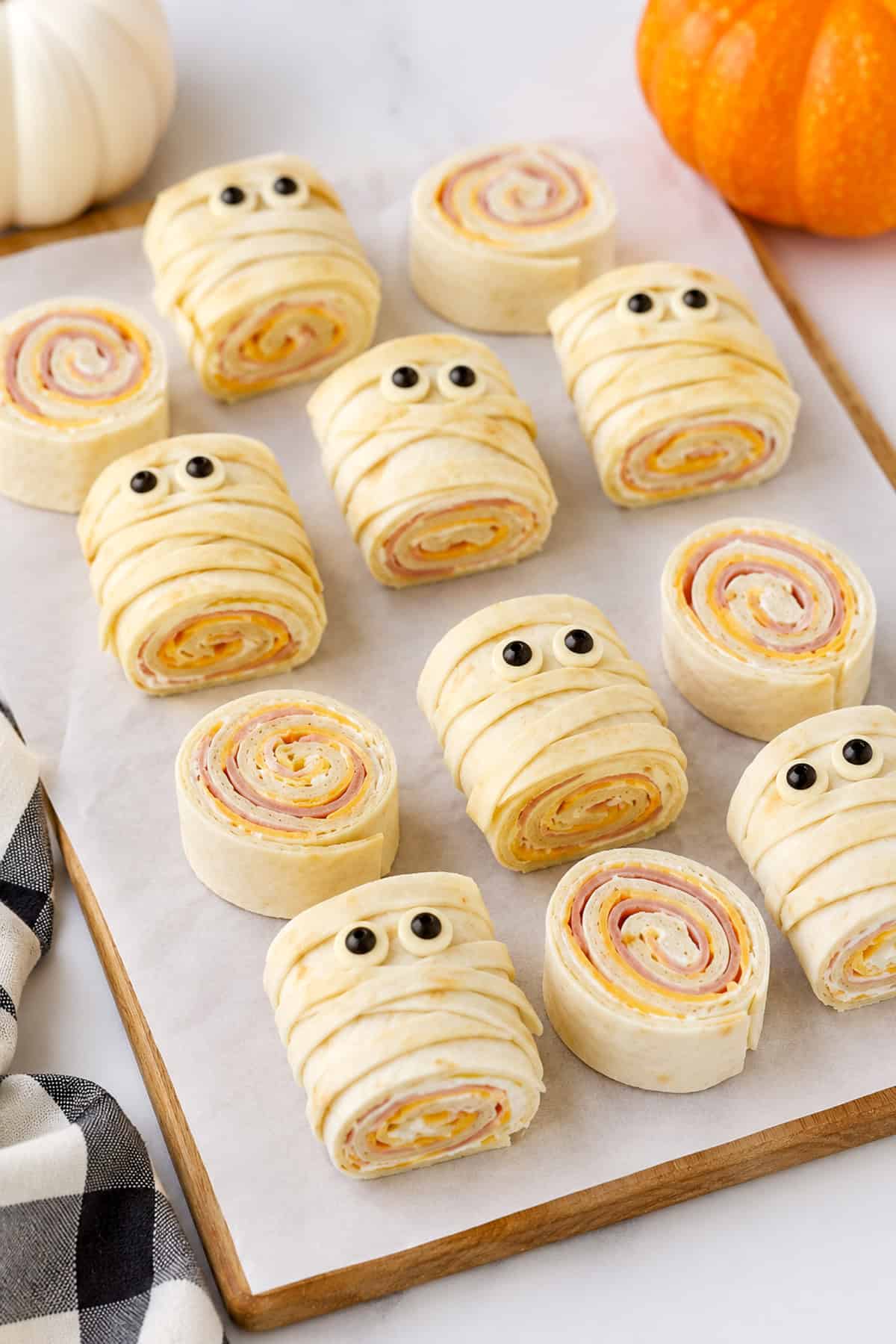 mummy pinwheel sandwiches on a cutting board
