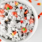 how to make easy muddy buddies for halloween, featured in a white bowl on a white background