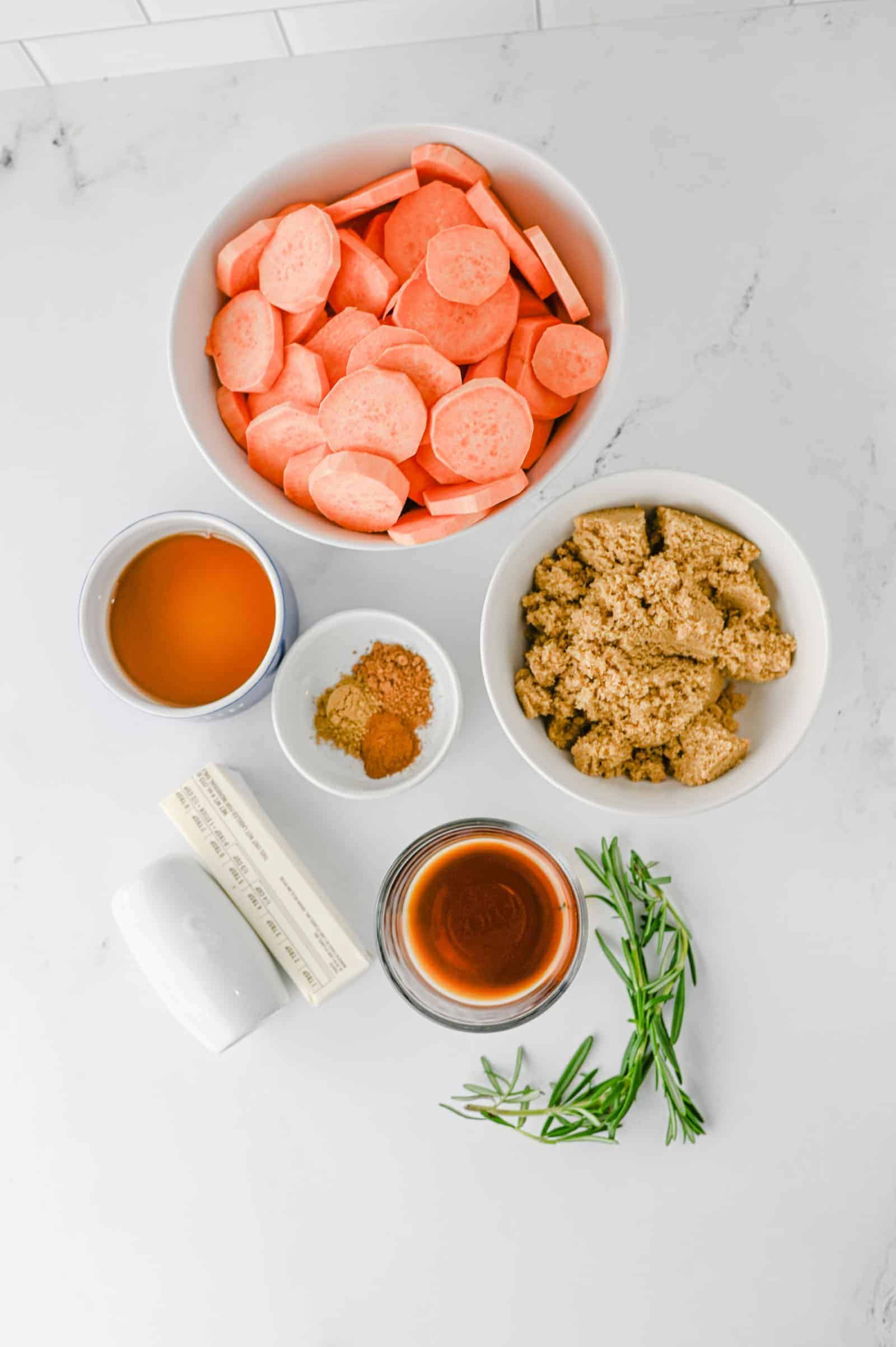 Ingredients for easy candied sweet potatoes: sweet potatoes, butter, maple syrup, brown sugar, spices, vanilla and fresh rosemary.