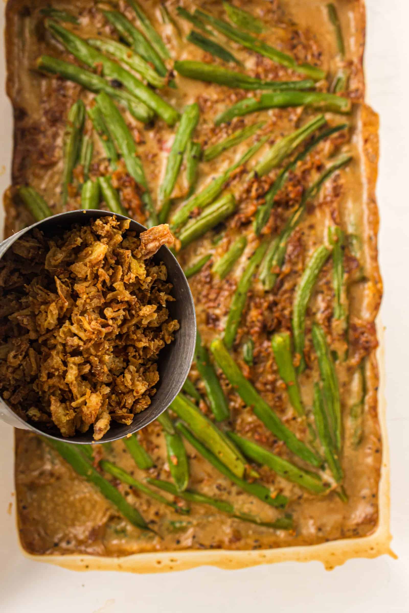 French fried onions sprinkled over green bean casserole before baking.