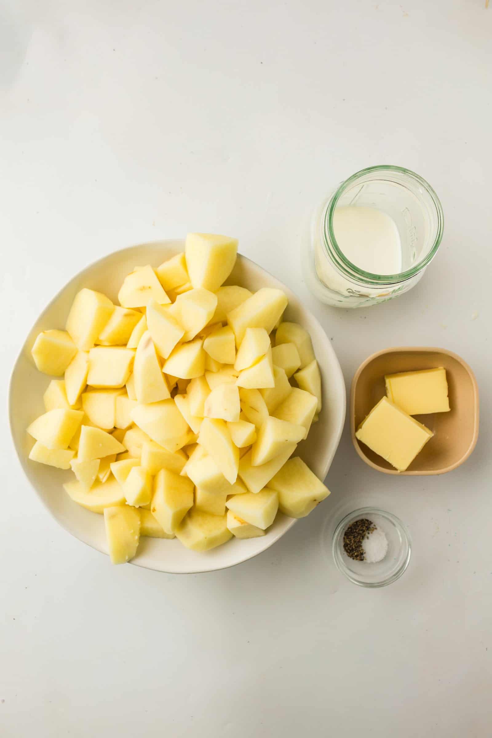 Ingredients for easy mashed potatoes: cubed potatoes, butter, milk and black pepper.