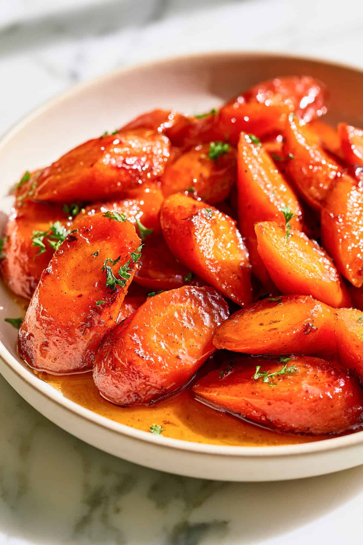 easy skillet carrots for the holidays in a white dish sprinkled with parsley