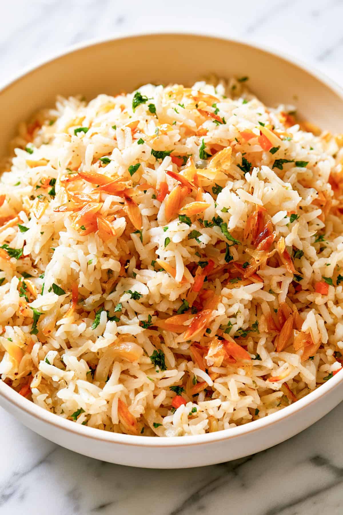 easy rice pilaf with toasted almonds for the holidays in a white bowl